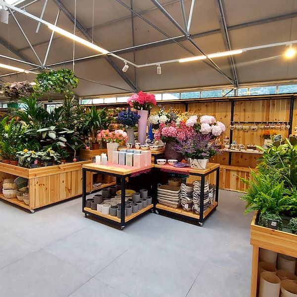 Tisch mit zwei Holzregalen auf Rollen